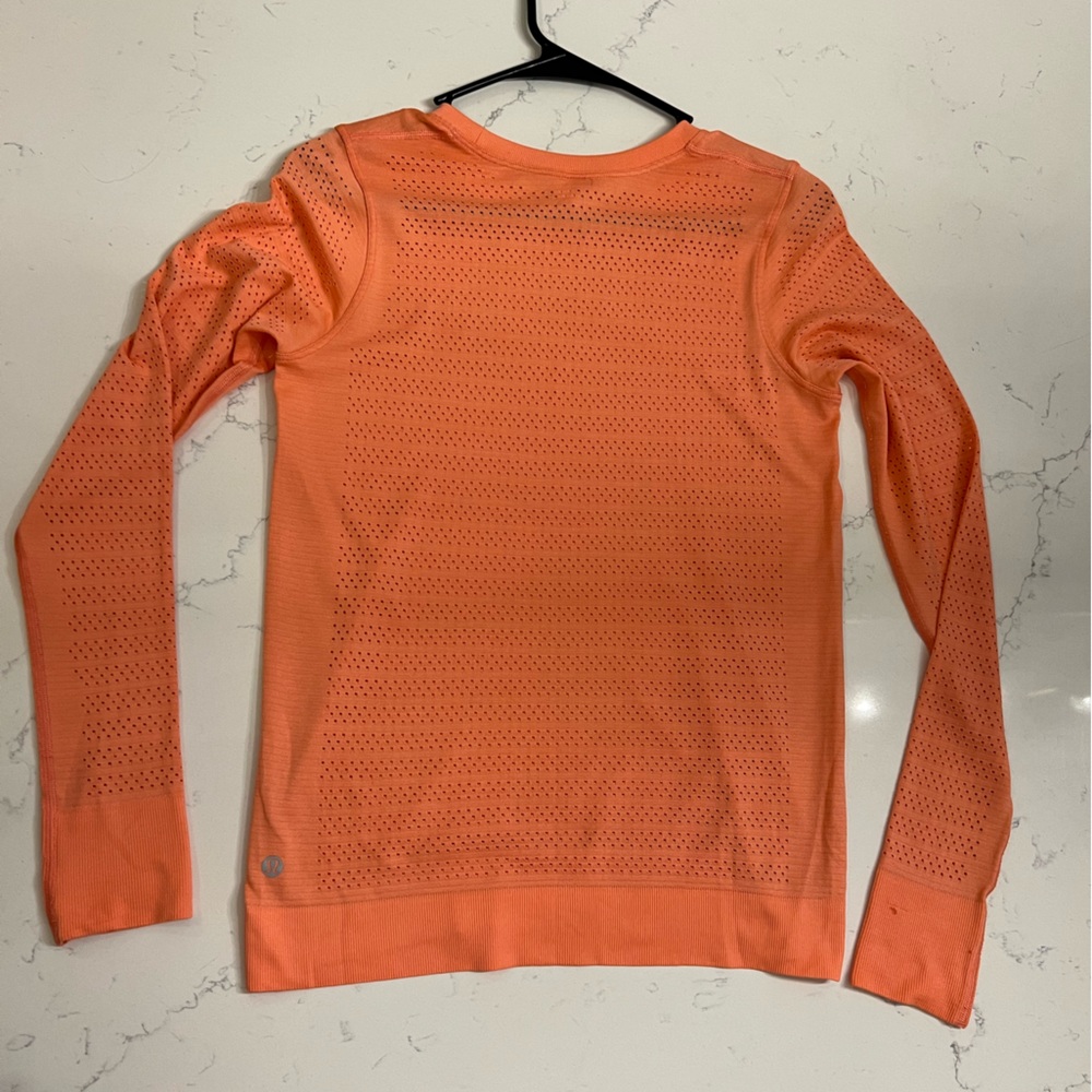 Lululemon Women’s Long sleeve Tee in an apricot/orange color.